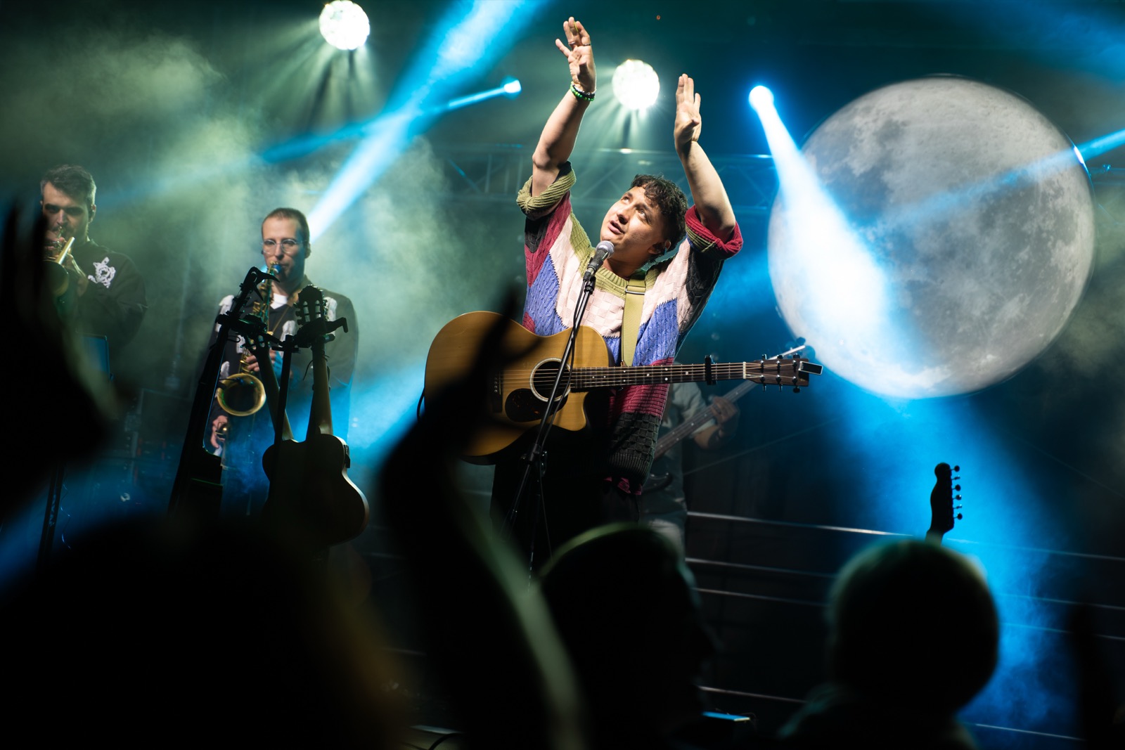 Wokalista z gitarą w światłach sceny